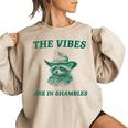 The Vibes Are In Shambles Sarcastic Raccoon Cowboy Women's Oversized Sweatshirt Sand